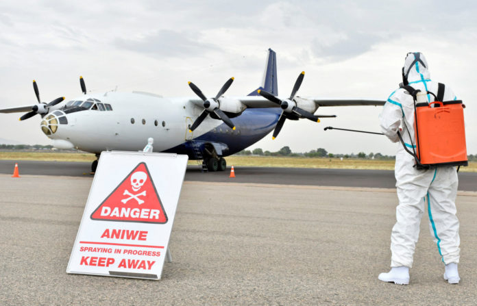 A member of a medical team wearing protective suits clean the airfield, to prevent the spread of the coronavirus disease (COVID-19), at the Juba International Airport in Juba