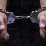 Man’s hand is locked with the handcuffs
