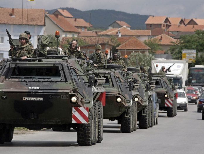 German KFOR soldiers in their vehicles enter the ethnically divided town of Mitrovica