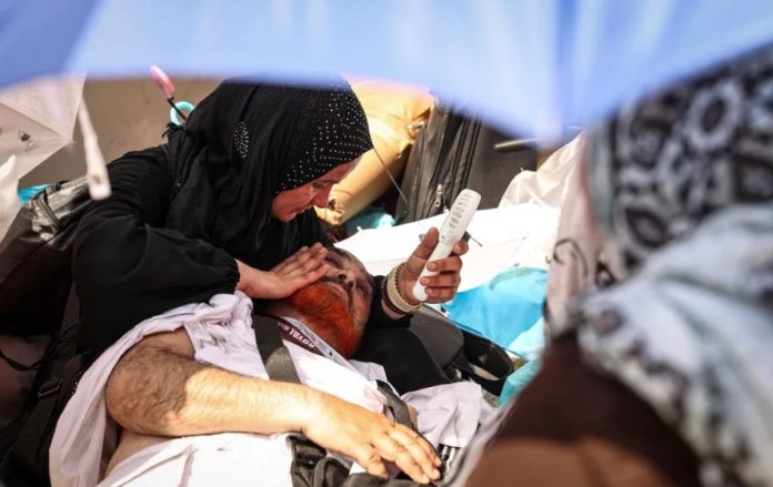 Nje-grua-perdor-nje-ventilator-per-te-freskuar-nje-burre-te-shtrire-ne-toke-gjate-Haxhit